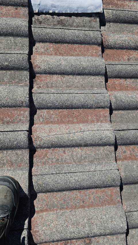 A clean crack runs right across the face of one concrete tile, easy to miss from the ground.
