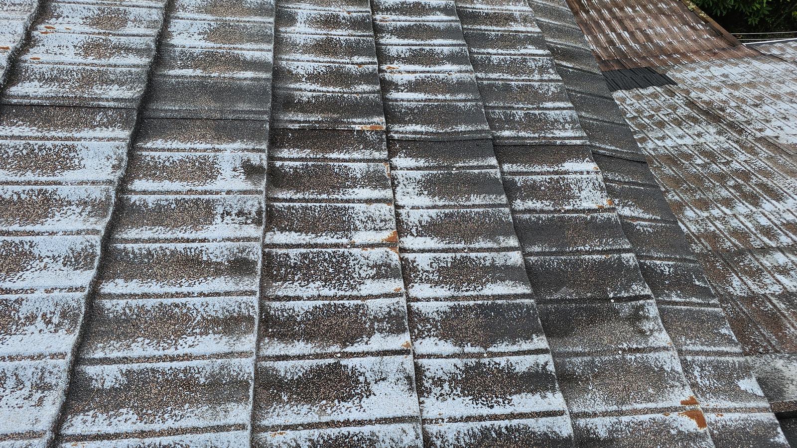 Decramastic tile roof with widespread stone chip loss and rust spots on the tiles