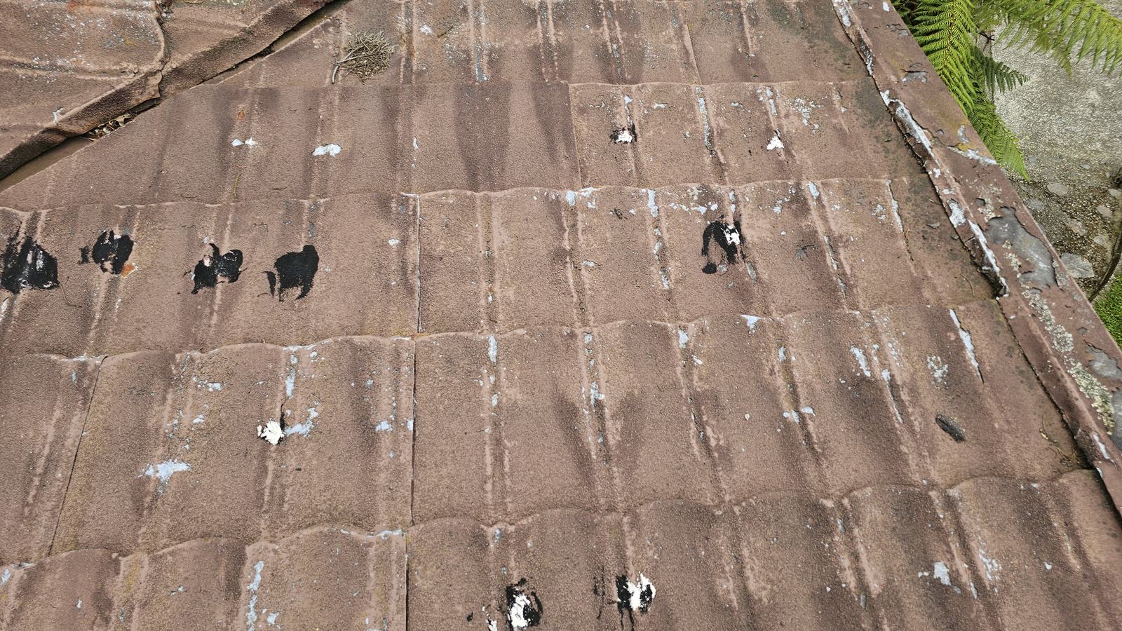 Decramastic tiles with heavy denting and daubs of silicone patch repairs