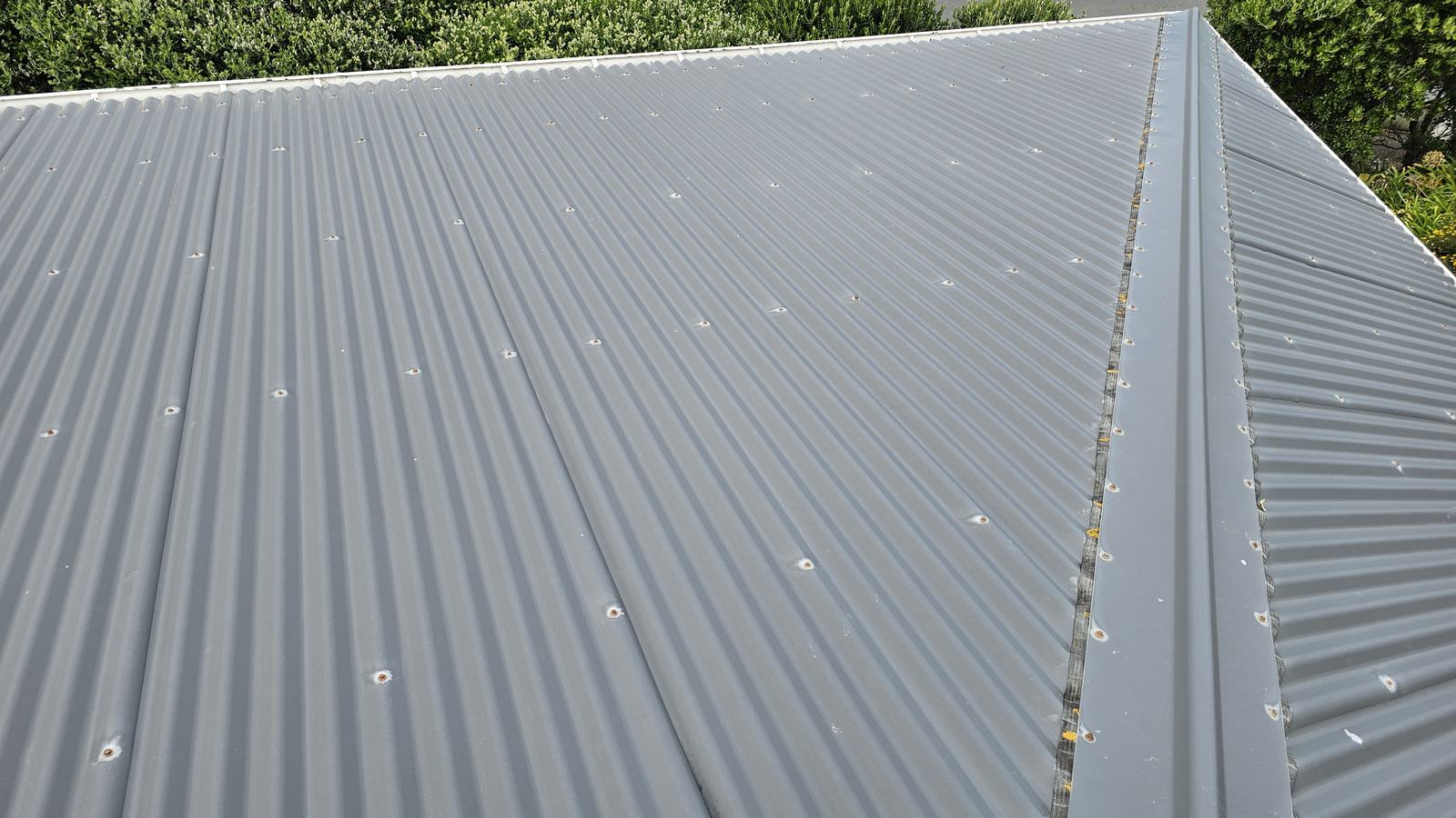 Oxidisation forming around screw fixings on a pre-painted corrugated metal roof