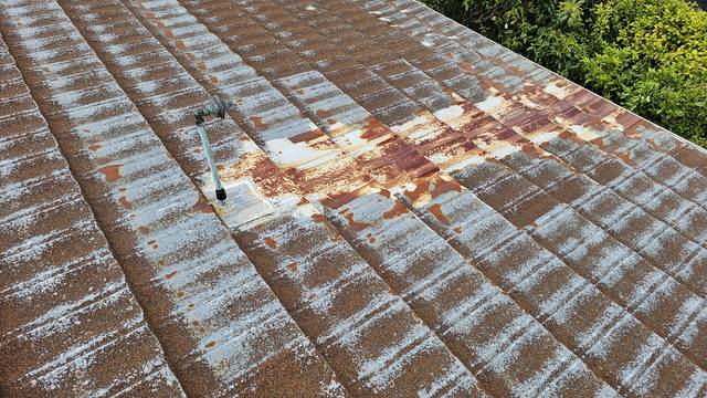 Heavy rust staining spreading down a Decratile roof, put down to water repeatedly overflowing across the same run of tiles.